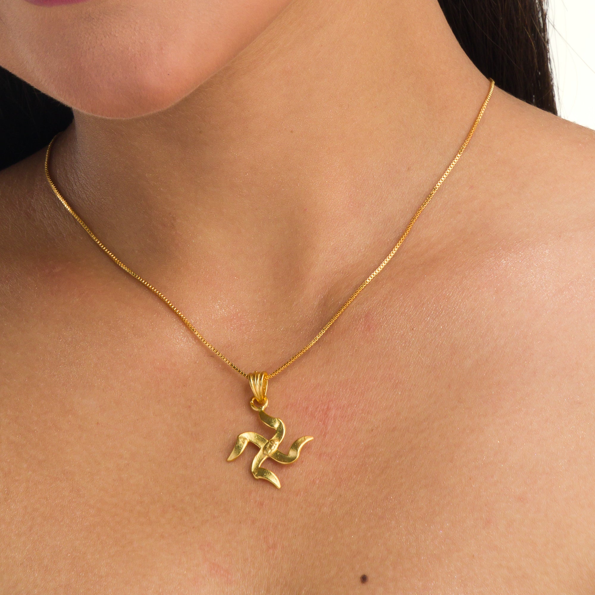 Elegant gold-tone pendant with a Swastik design, perfect for casual wear, adding a meaningful touch."