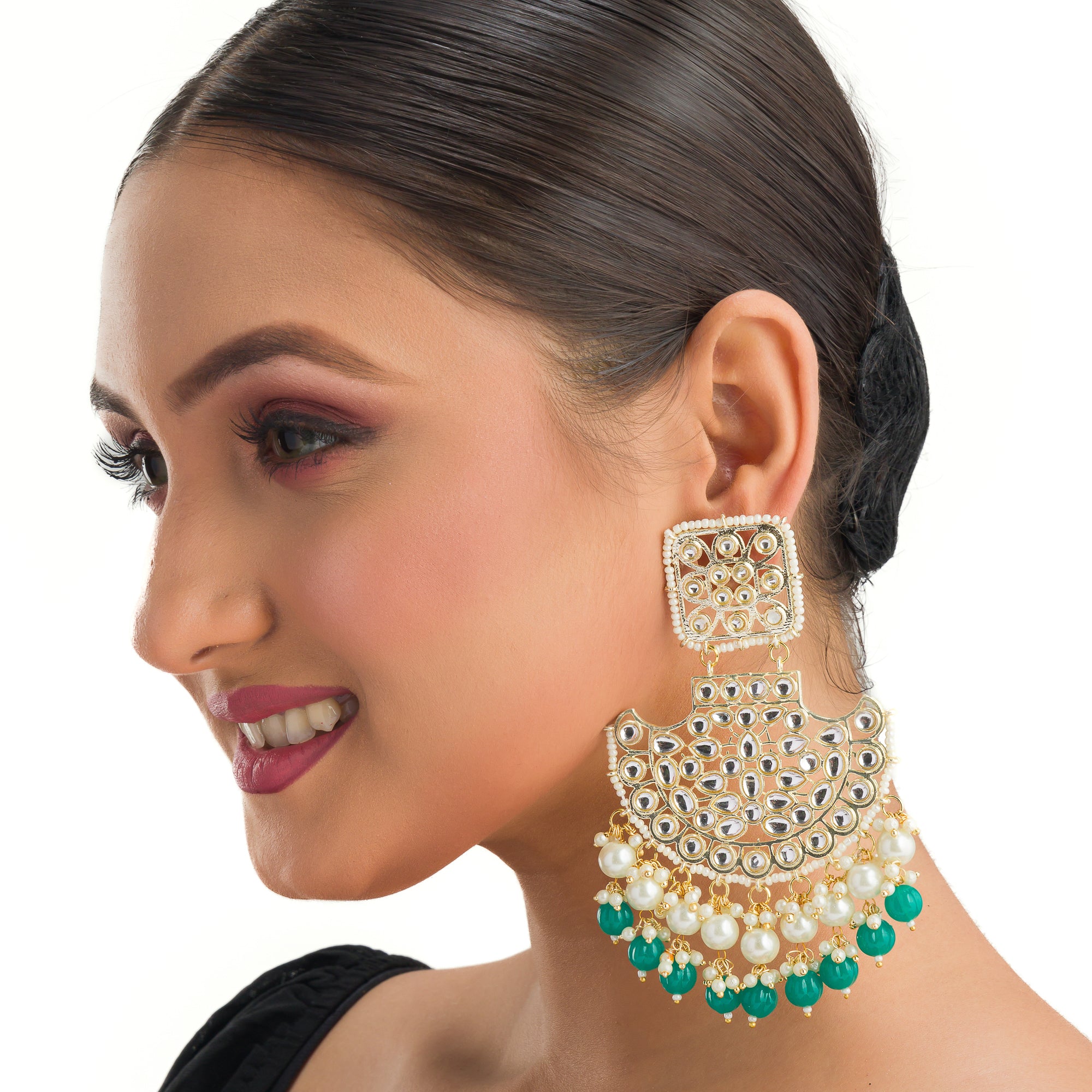 1. "Kundan channbali earrings with green and white pearls offer a regal, timeless allure."