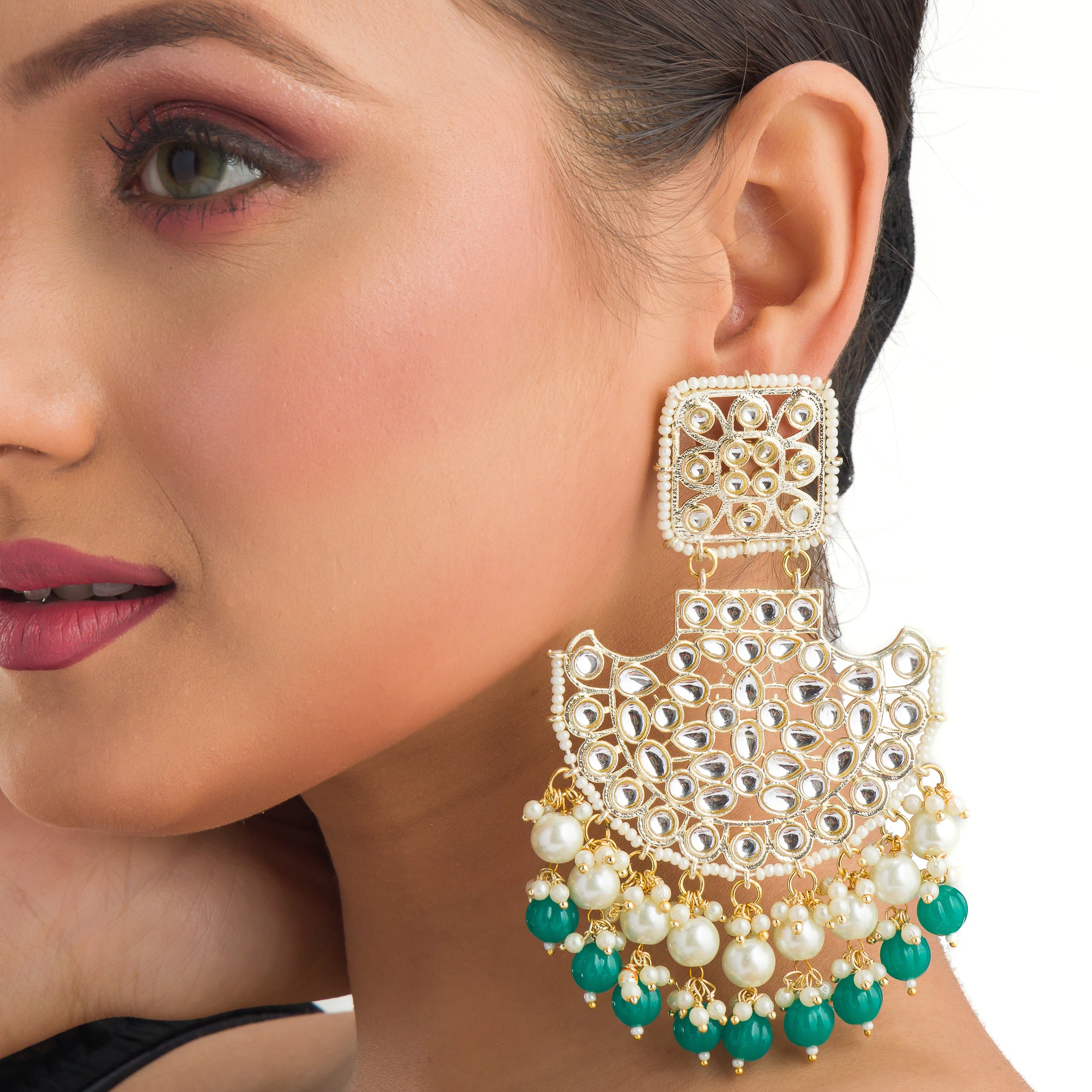 1. "Kundan channbali earrings with green and white pearls offer a regal, timeless allure."