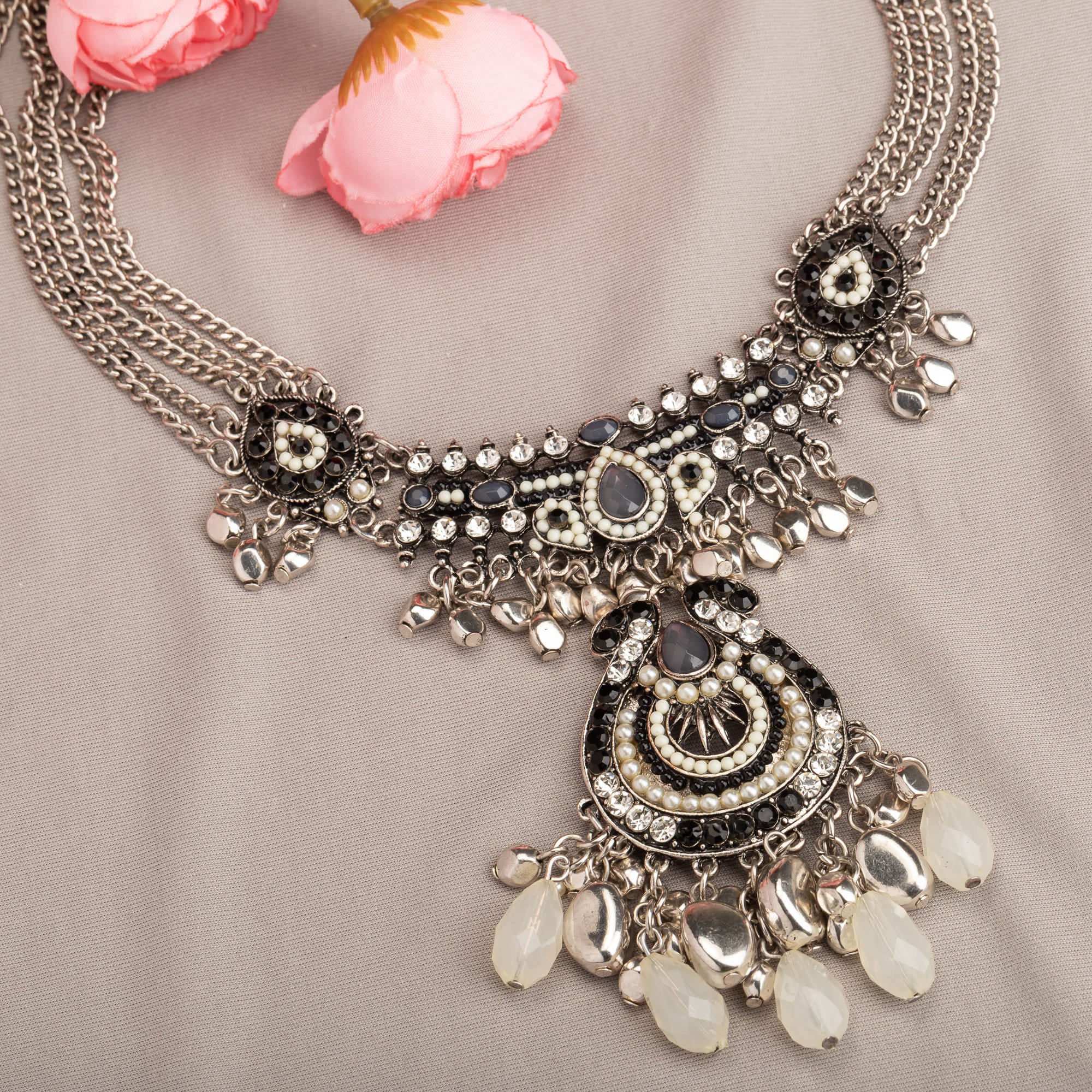 "Oxidized silver necklace with black and white beads adds stylish contrast."