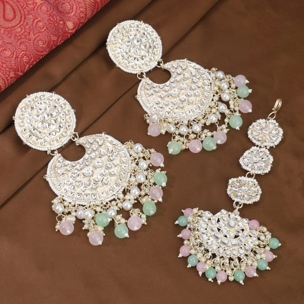 "Multicolor Kundan and pearl earrings with Maang Tikka, perfect for a classic festive style."