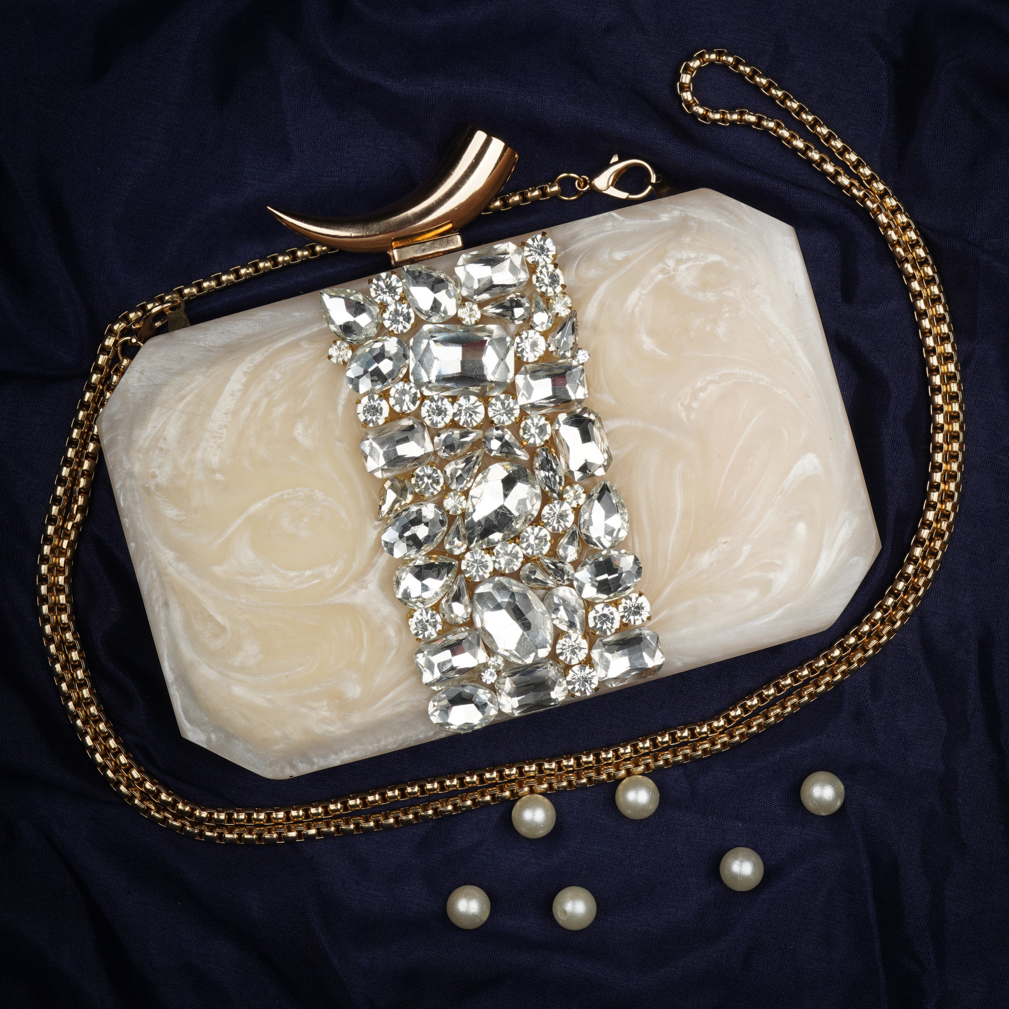 Salmon resin clutch with stone embellishments, soft lining, and extra pocket for practical storage.