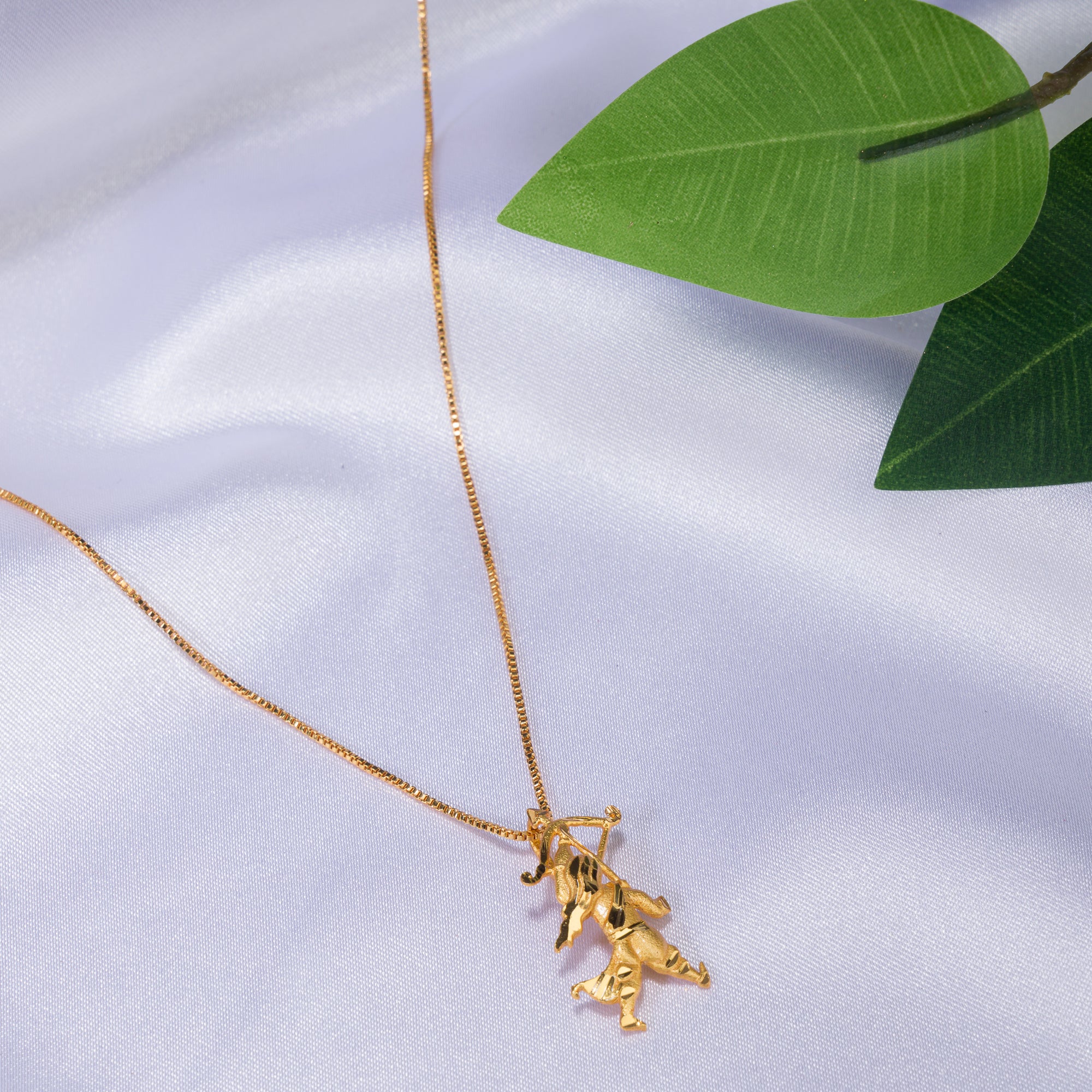 "Gold-tone pendant of a boy with a bow (dhanush), perfect for casual wear, adding a playful touch."
