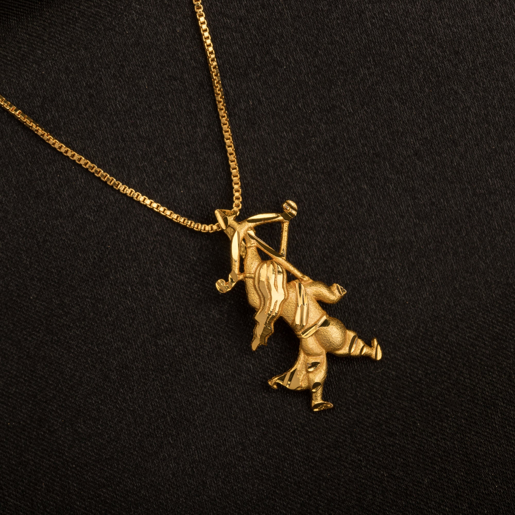 "Gold-tone pendant of a boy with a bow (dhanush), perfect for casual wear, adding a playful touch."
