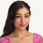 "Gold-tone pendant of a boy with a bow (dhanush), perfect for casual wear, adding a playful touch."
