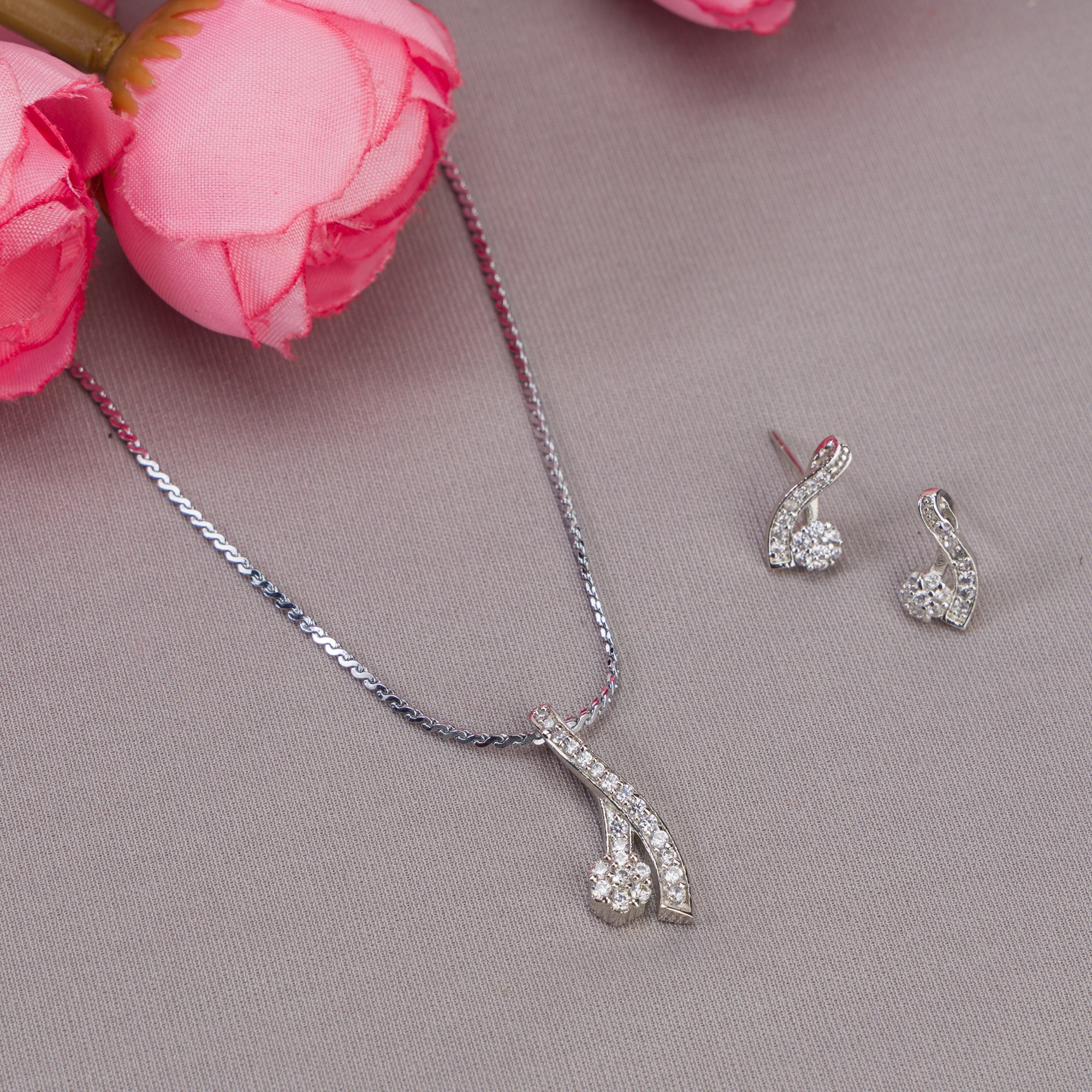 "Elegant zircon pendant set for neck and ear, perfect for casual wear, featuring a stylish '&' shape."
