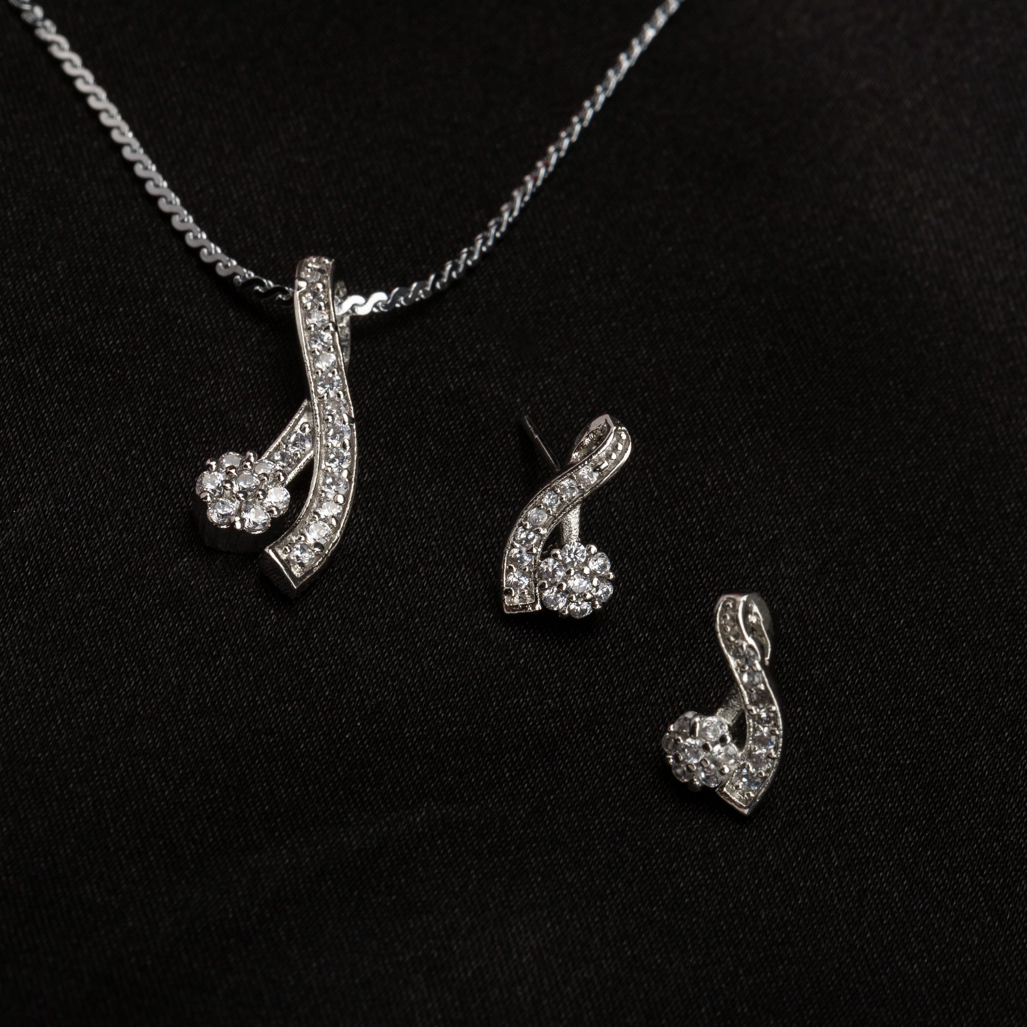 "Elegant zircon pendant set for neck and ear, perfect for casual wear, featuring a stylish '&' shape."
