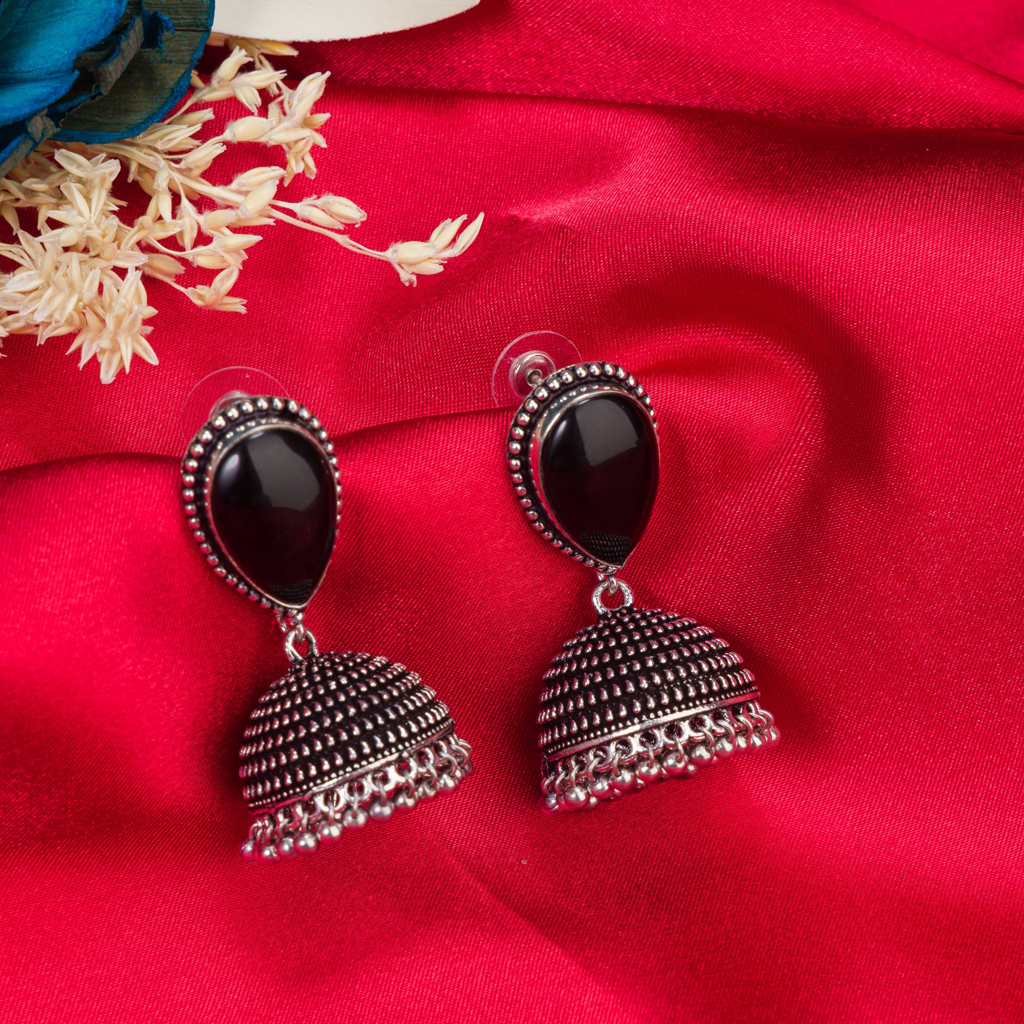 "Oxidized jhumka earrings with a black stone center deliver a striking vintage allure for festivals."
