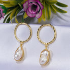 "Golden earrings with white uncut stones blend classic elegance with modern flair."
