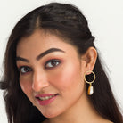 "Golden earrings with white uncut stones blend classic elegance with modern flair."
