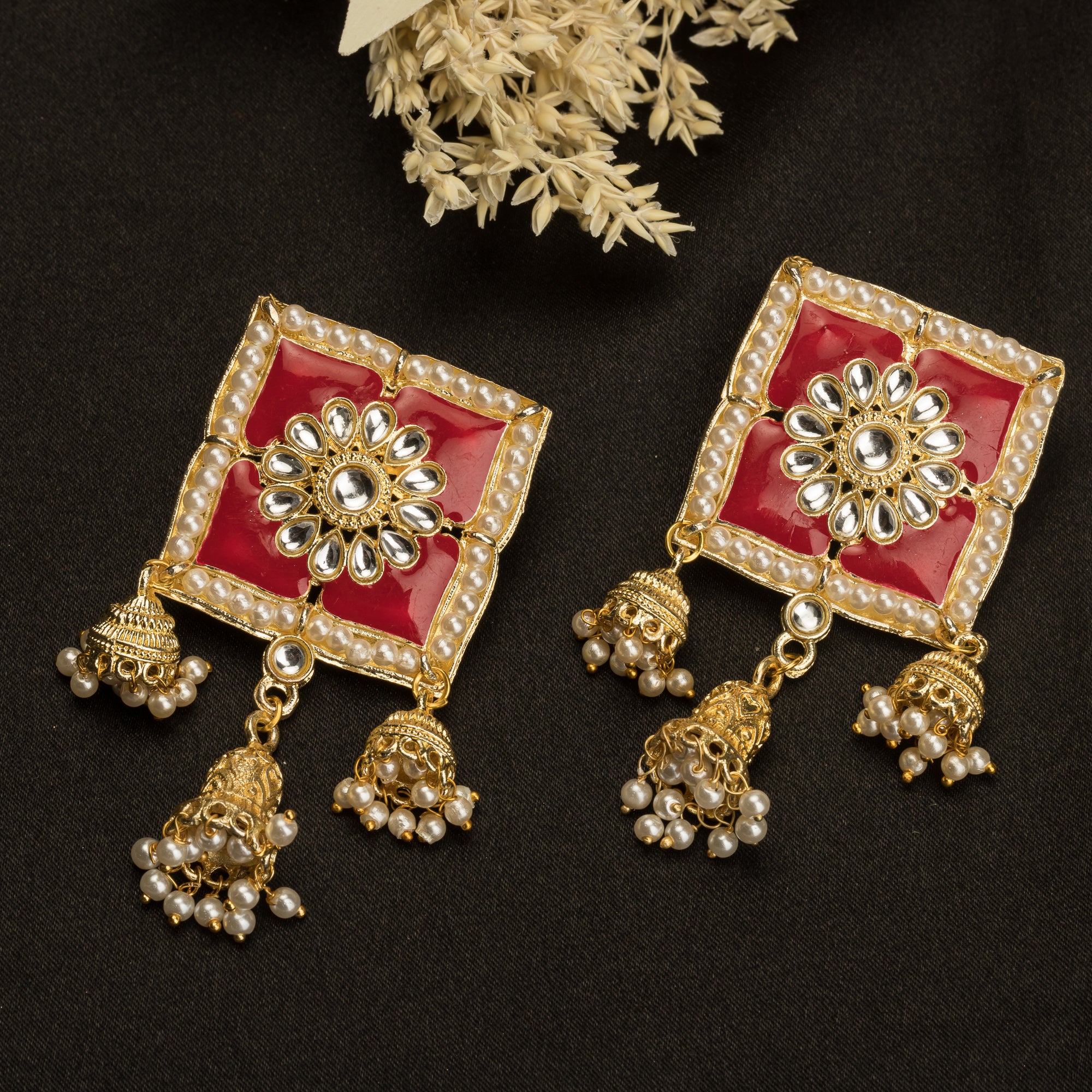 1. "Red square gold jhumka blends bold color and classic elegance for a striking look."
