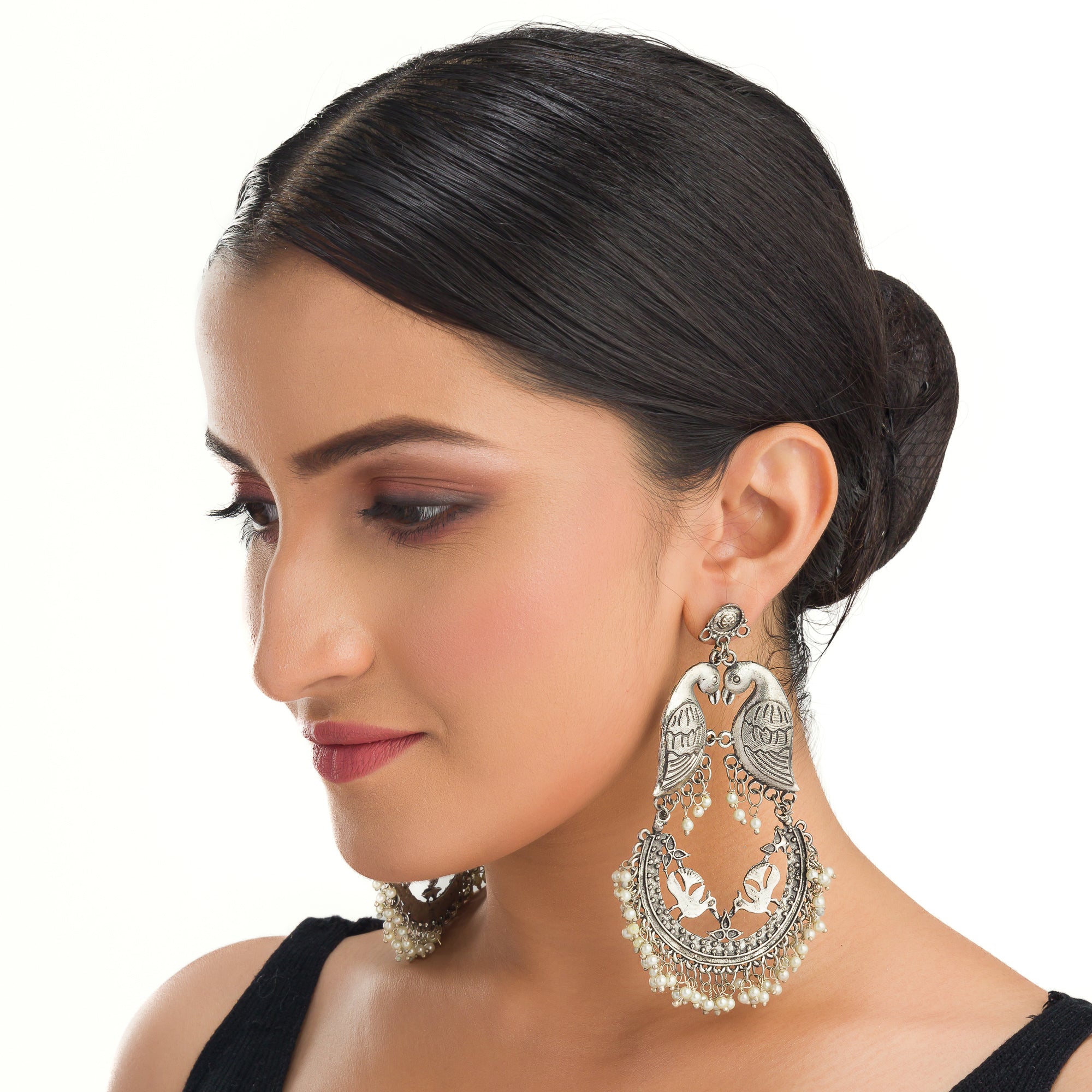 "Small oxidized earrings with two birds add vintage charm with intricate details."
