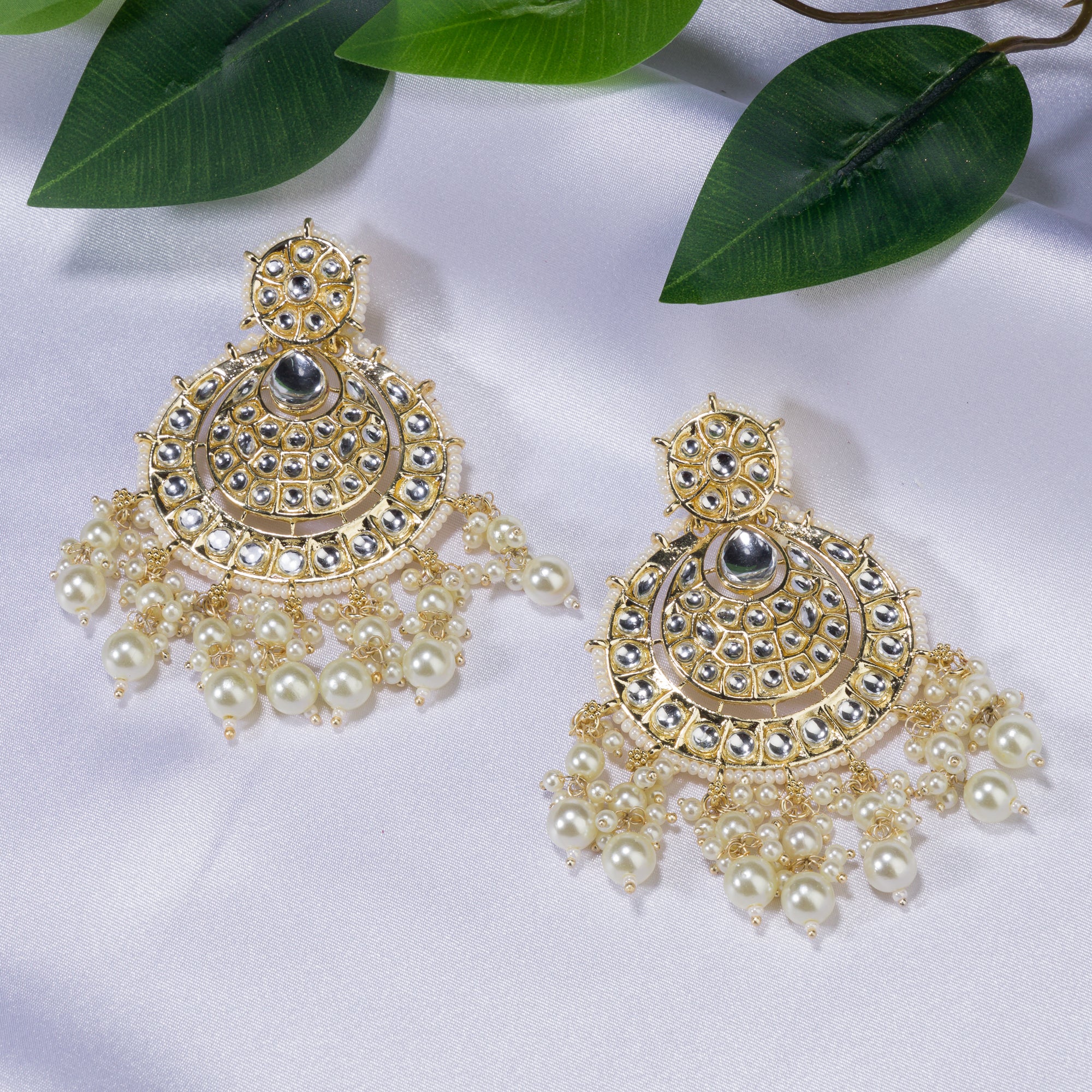 "Chandbali Kundan earrings with intricate design make a bold, regal statement."
