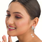 "Silver zircon earrings with hanging pearls offer elegant sparkle and sophistication."
