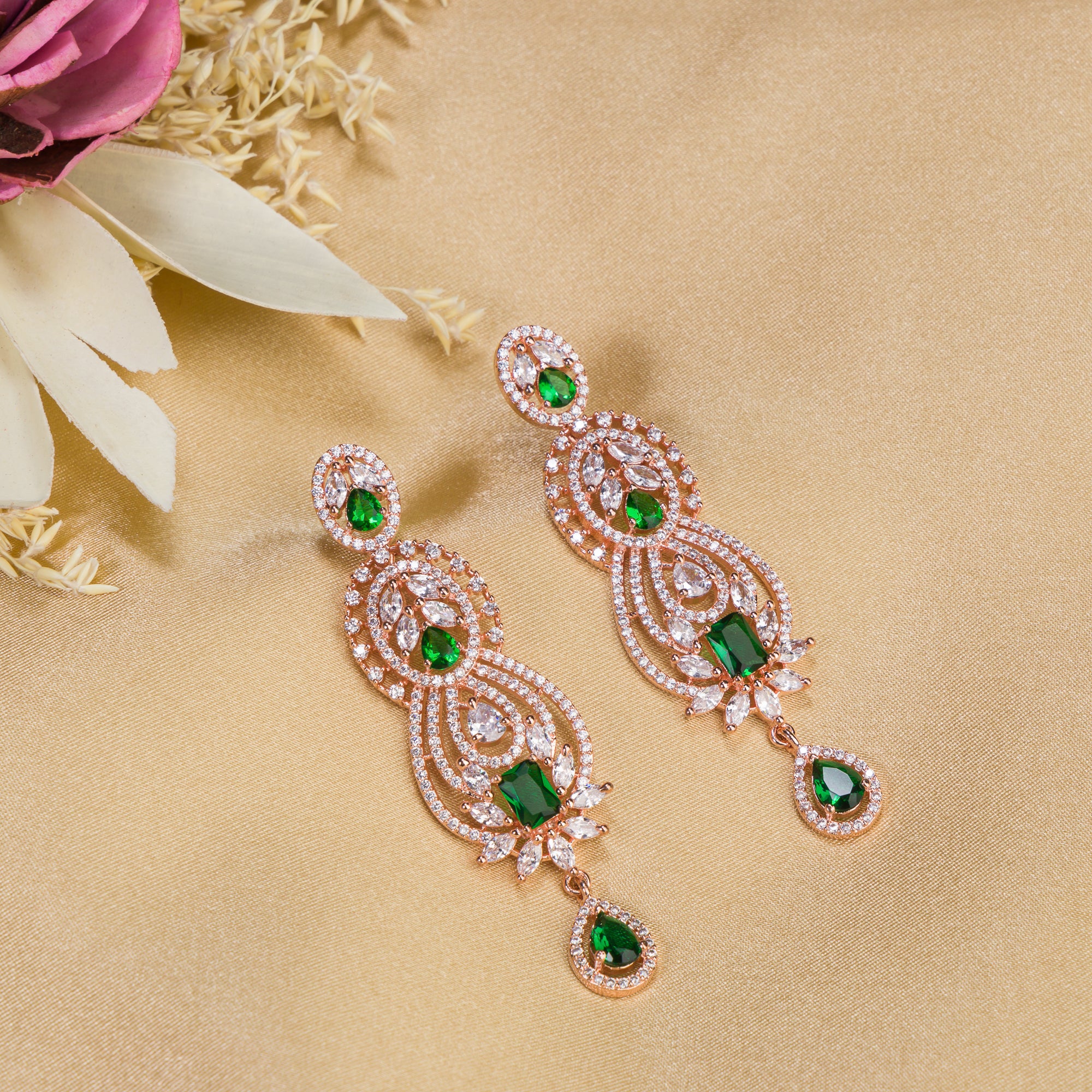 Green and white zircon earrings with rose gold polish exude vibrant elegance and style."
