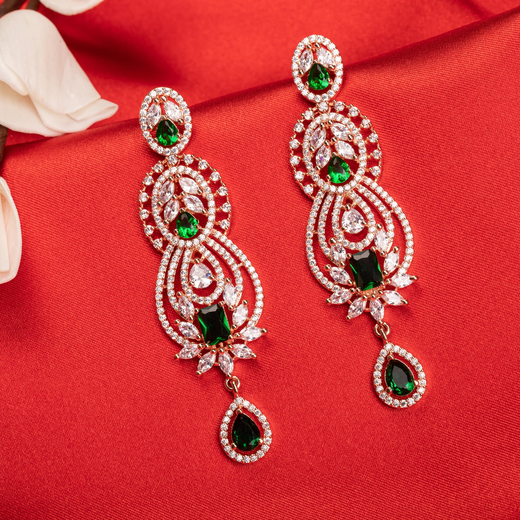 Green and white zircon earrings with rose gold polish exude vibrant elegance and style."
