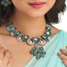Tree-shaped necklace with green and white zircons brings a unique, elegant charm to any party look.
