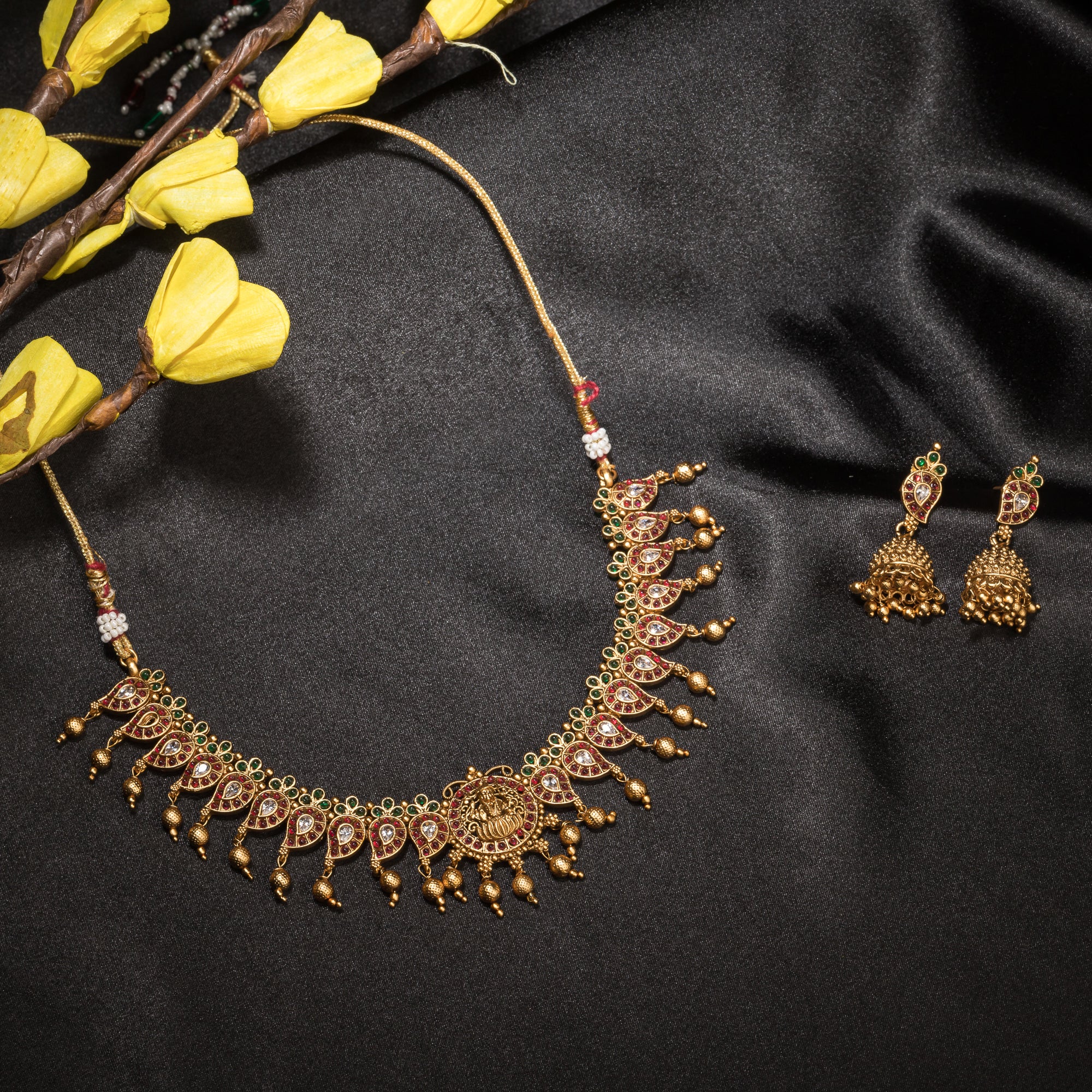Gold long necklace with multi-color stones exudes vibrant elegance for a festive celebration.
