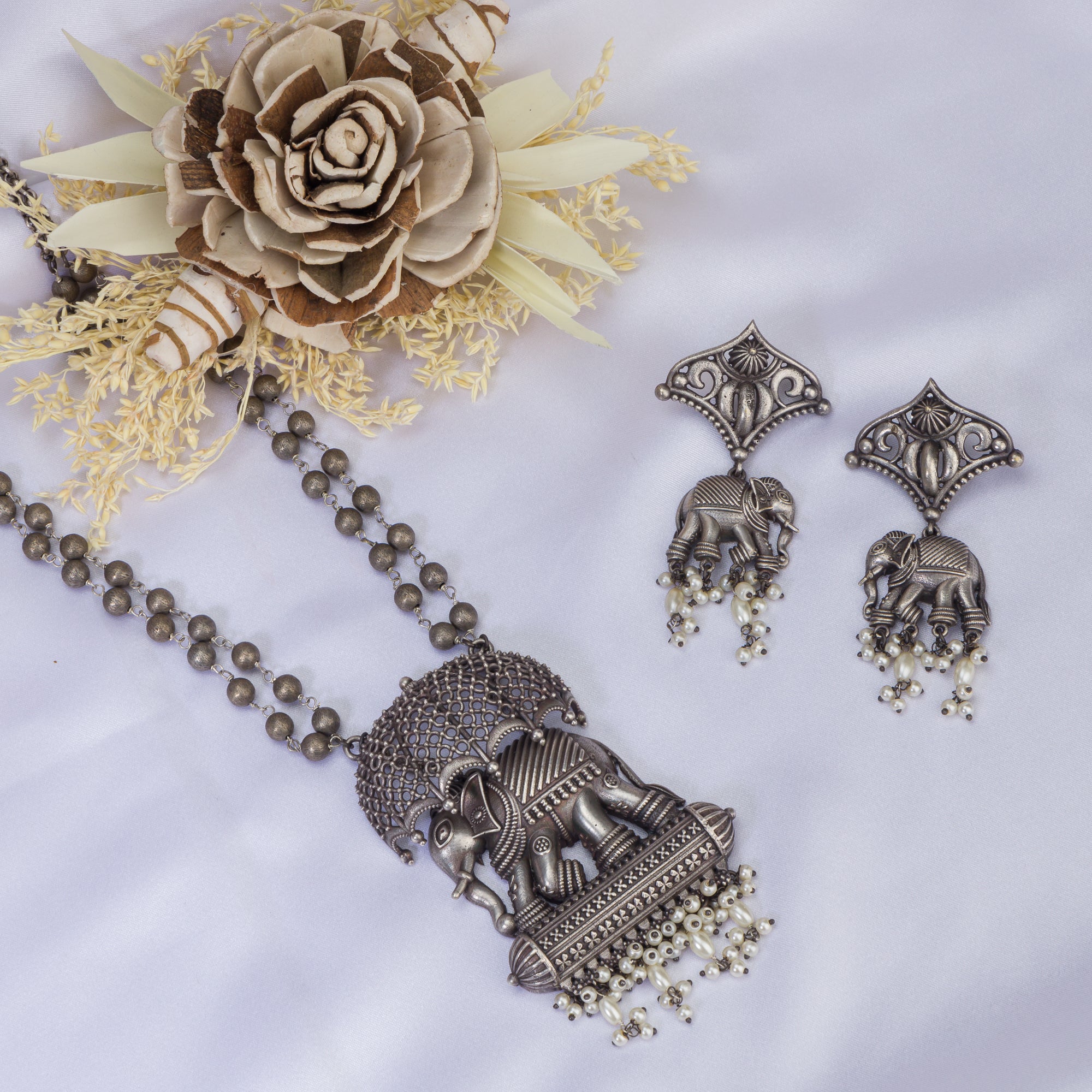 "Oxidized long necklace with umbrella, elephant motifs, and white pearls exudes vintage elegance."
