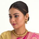 Coin-style gold-tone temple necklace exudes classic elegance and timeless tradition.
