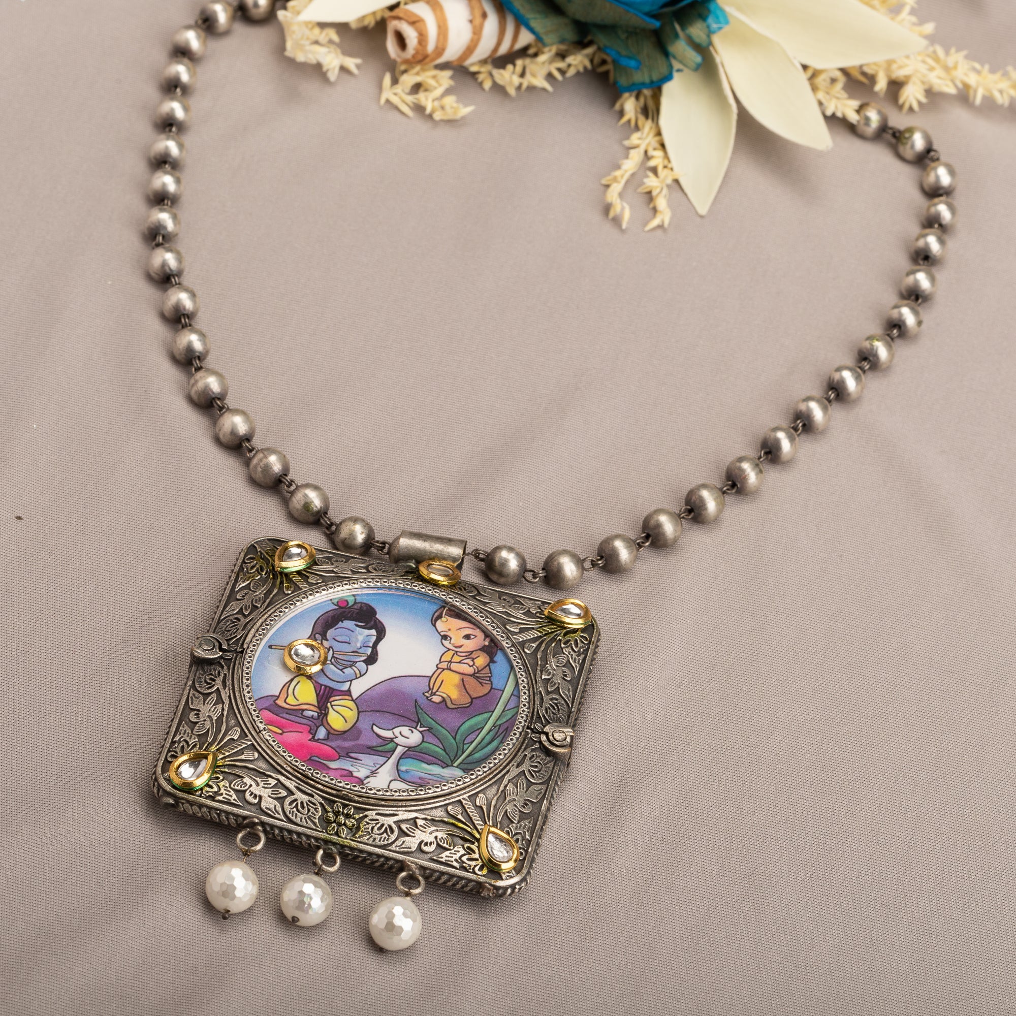 "Oxidized long necklace with Radha Krishna image brings spiritual charm."
