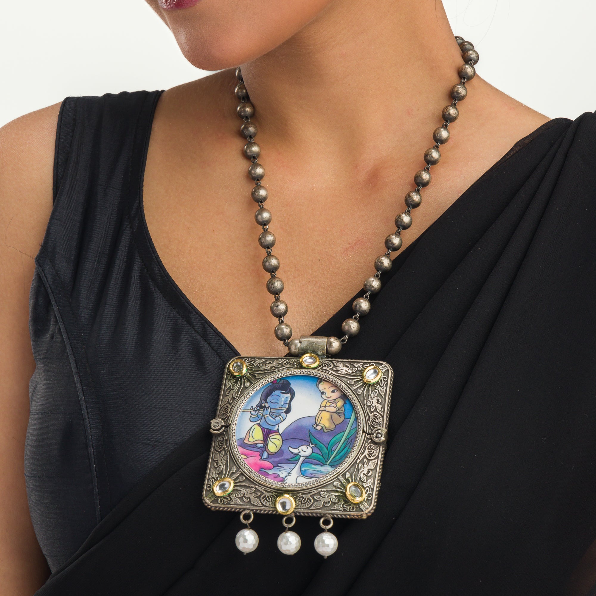 "Oxidized long necklace with Radha Krishna image brings spiritual charm."
