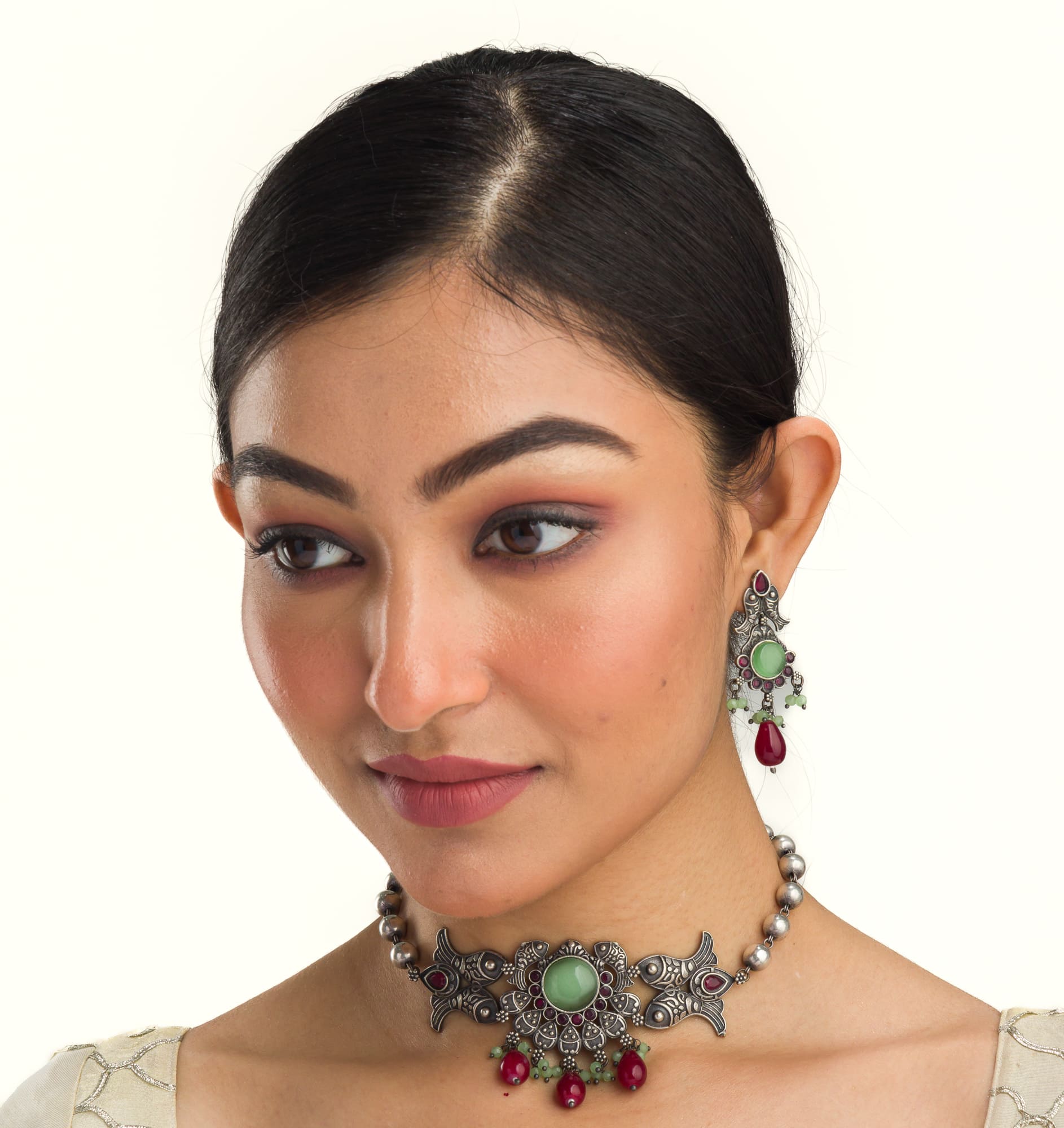 Oxidized choker with light green stones and maroon Kundan blends unique charm.
