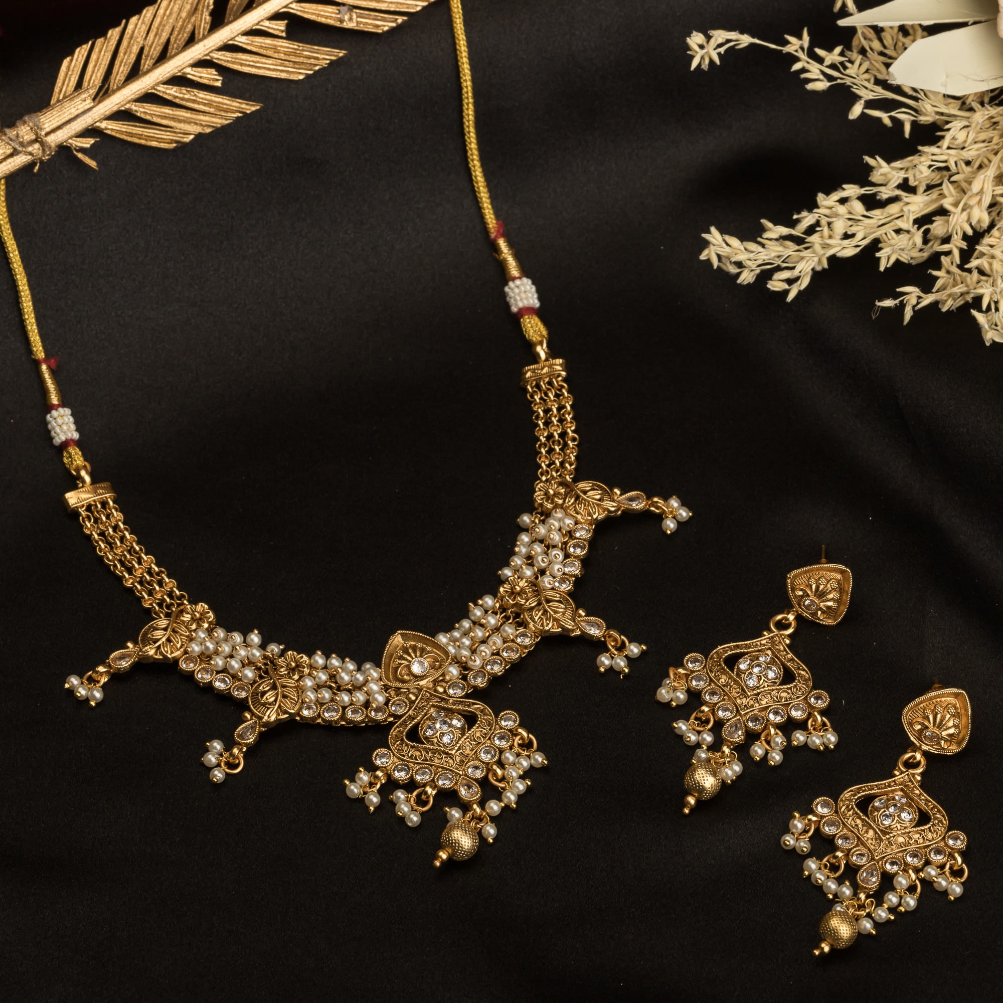 "Gold-tone necklace set with white pearls for a classic and elegant look."
