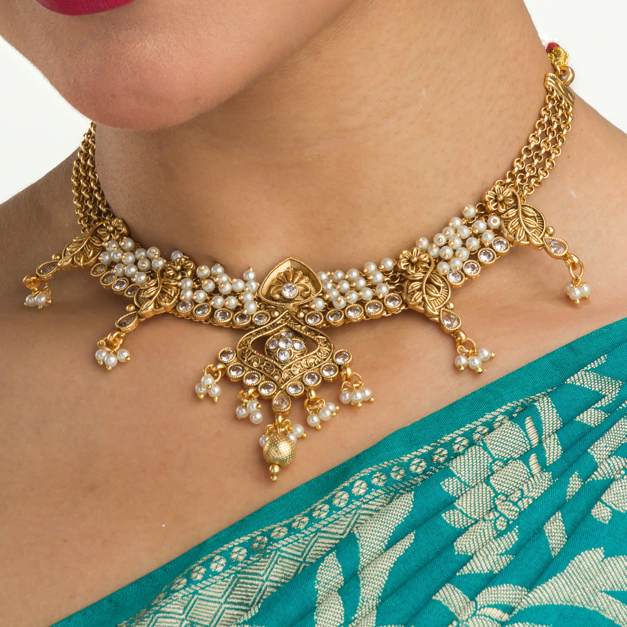 "Gold-tone necklace set with white pearls for a classic and elegant look."
