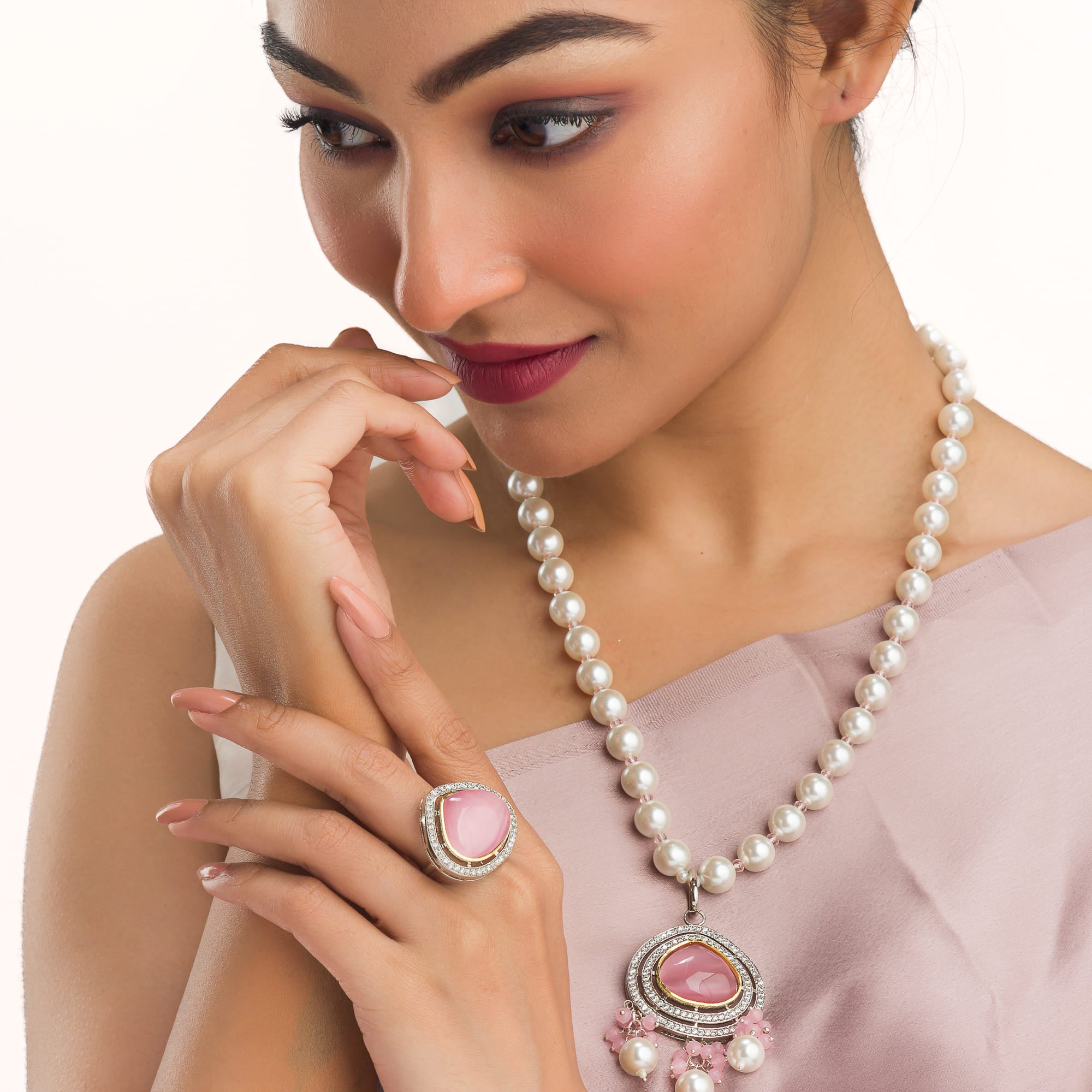 "Graceful pink pendant on a white pearl long necklace for a feminine touch."
