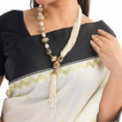 "Elegant white pearl long necklace with golden accents for a glamorous finish."

