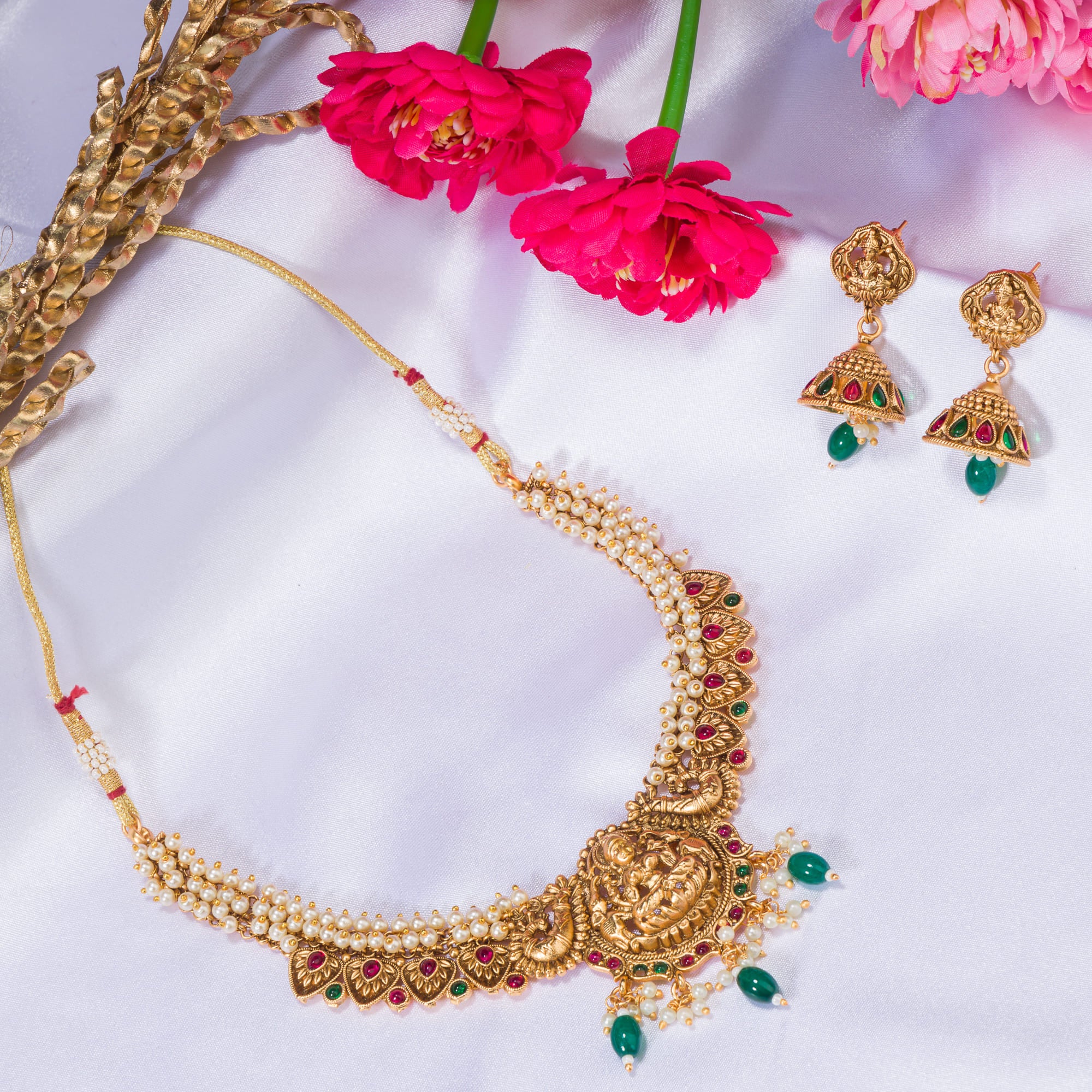 "Gold-tone necklace with white pearl and green Kundan for a timeless traditional look."
