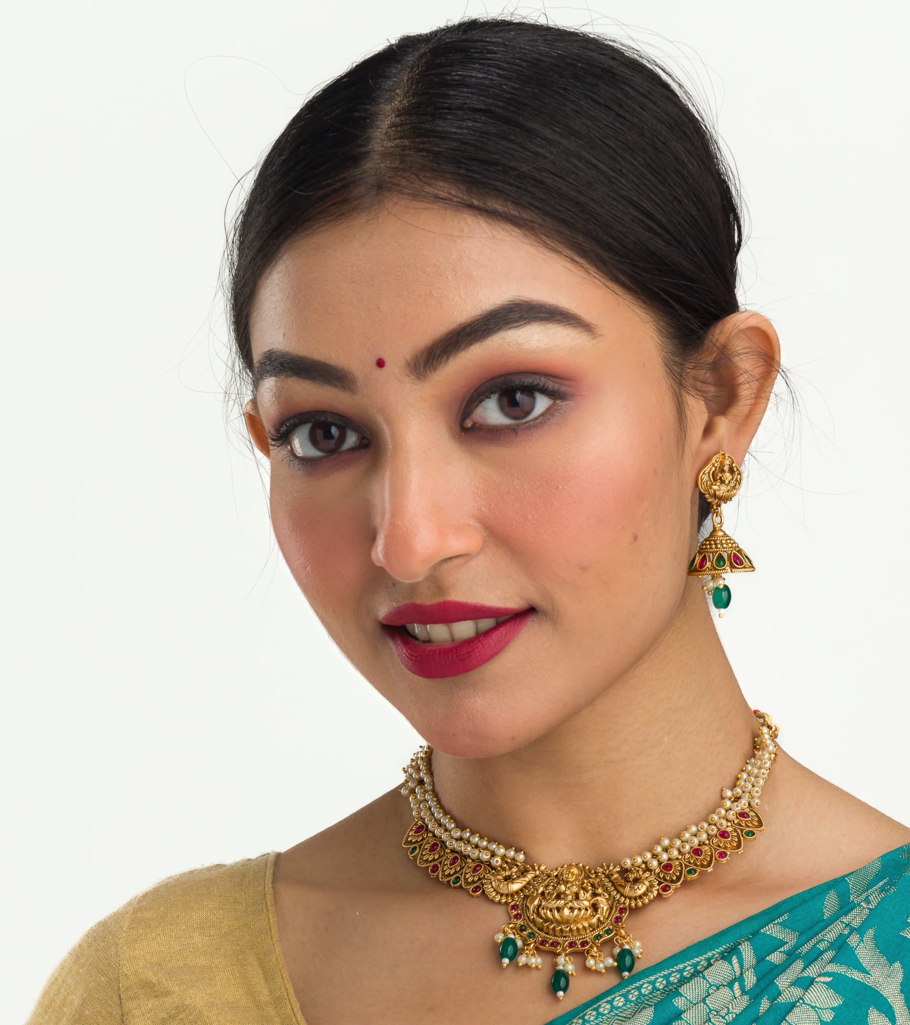 "Gold-tone necklace with white pearl and green Kundan for a timeless traditional look."
