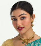 "Gold-tone necklace with white pearl and green Kundan for a timeless traditional look."
