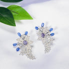 "Zircon flower-shaped earrings with a blue zircon center add vibrant sparkle."
