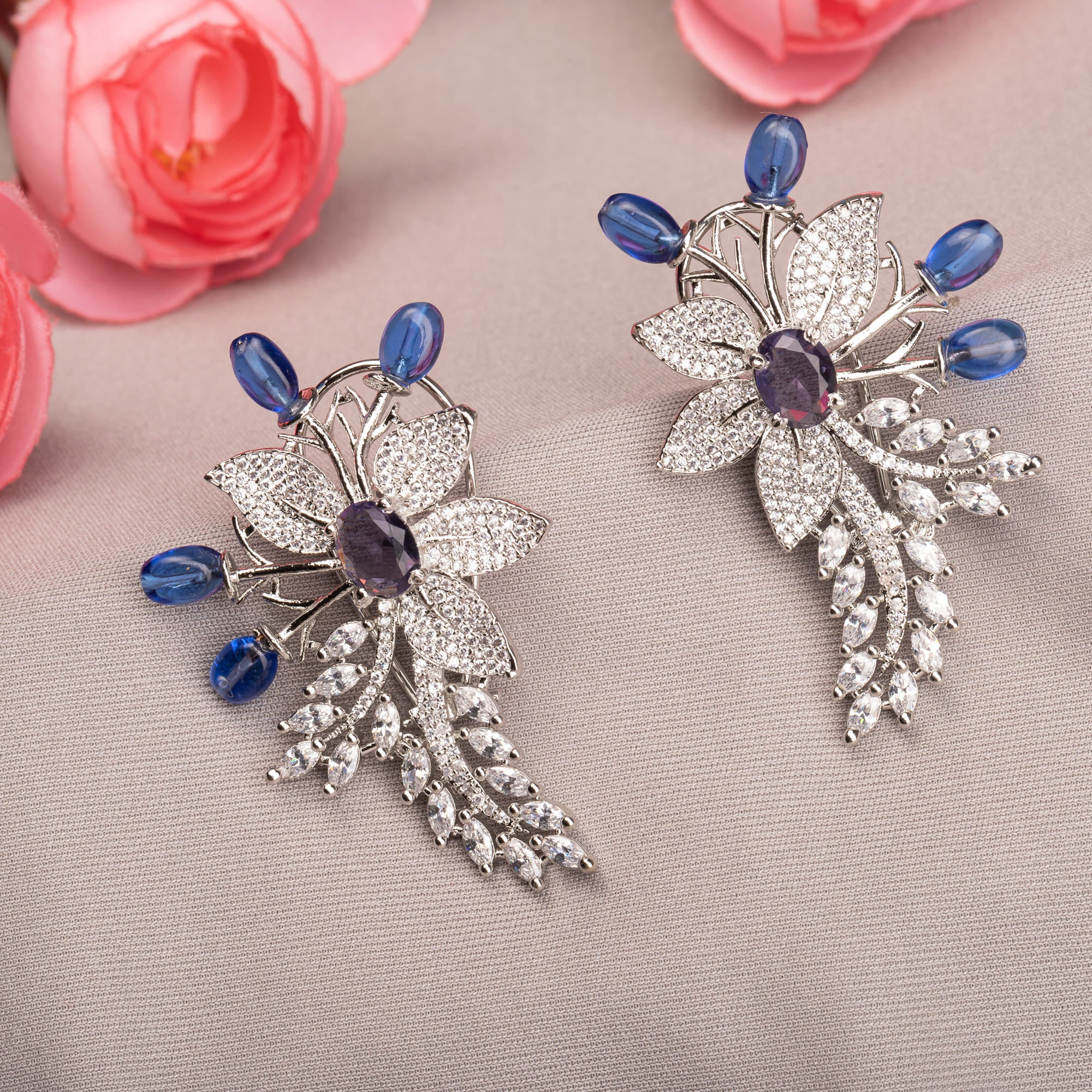 "Zircon flower-shaped earrings with a blue zircon center add vibrant sparkle."
