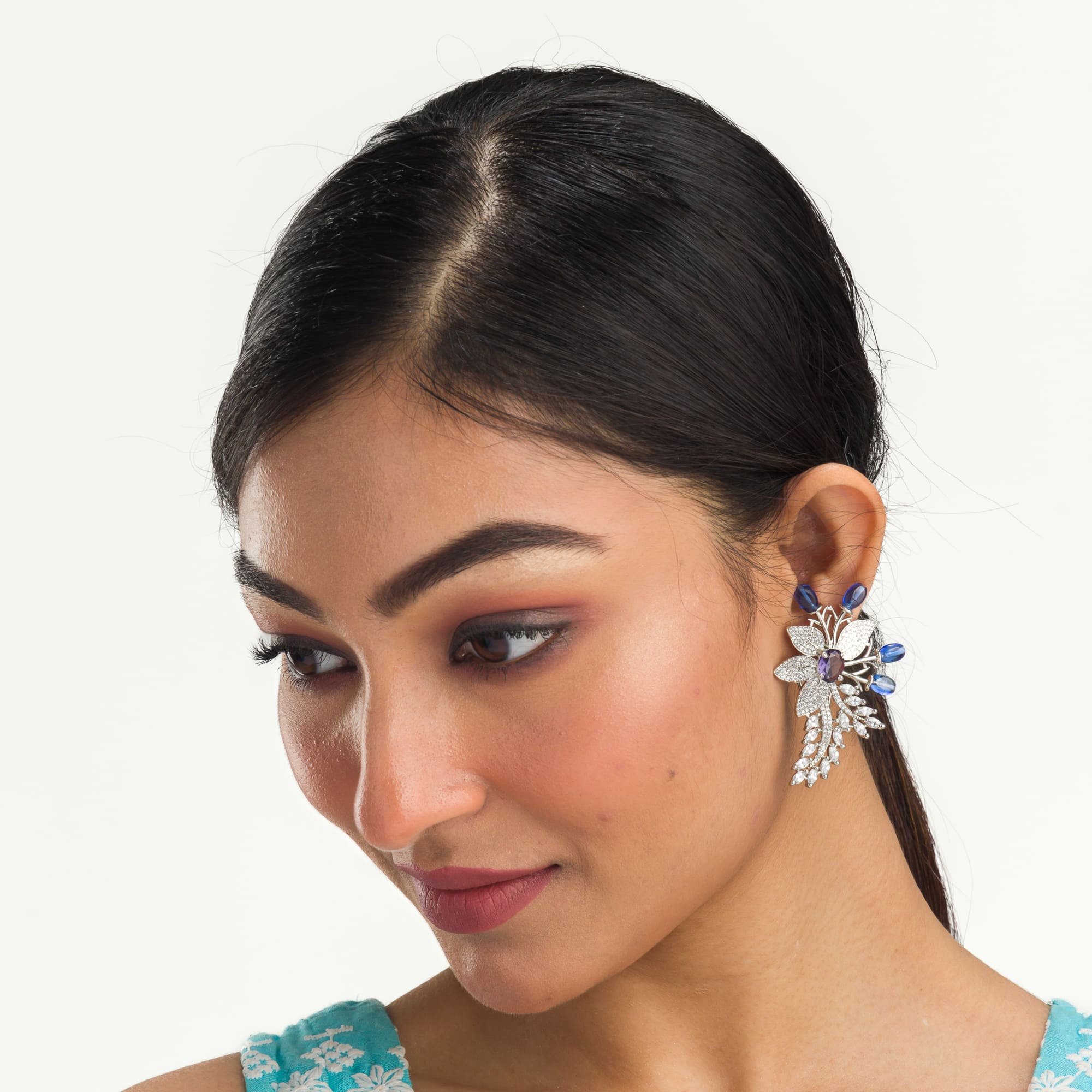 "Zircon flower-shaped earrings with a blue zircon center add vibrant sparkle."
