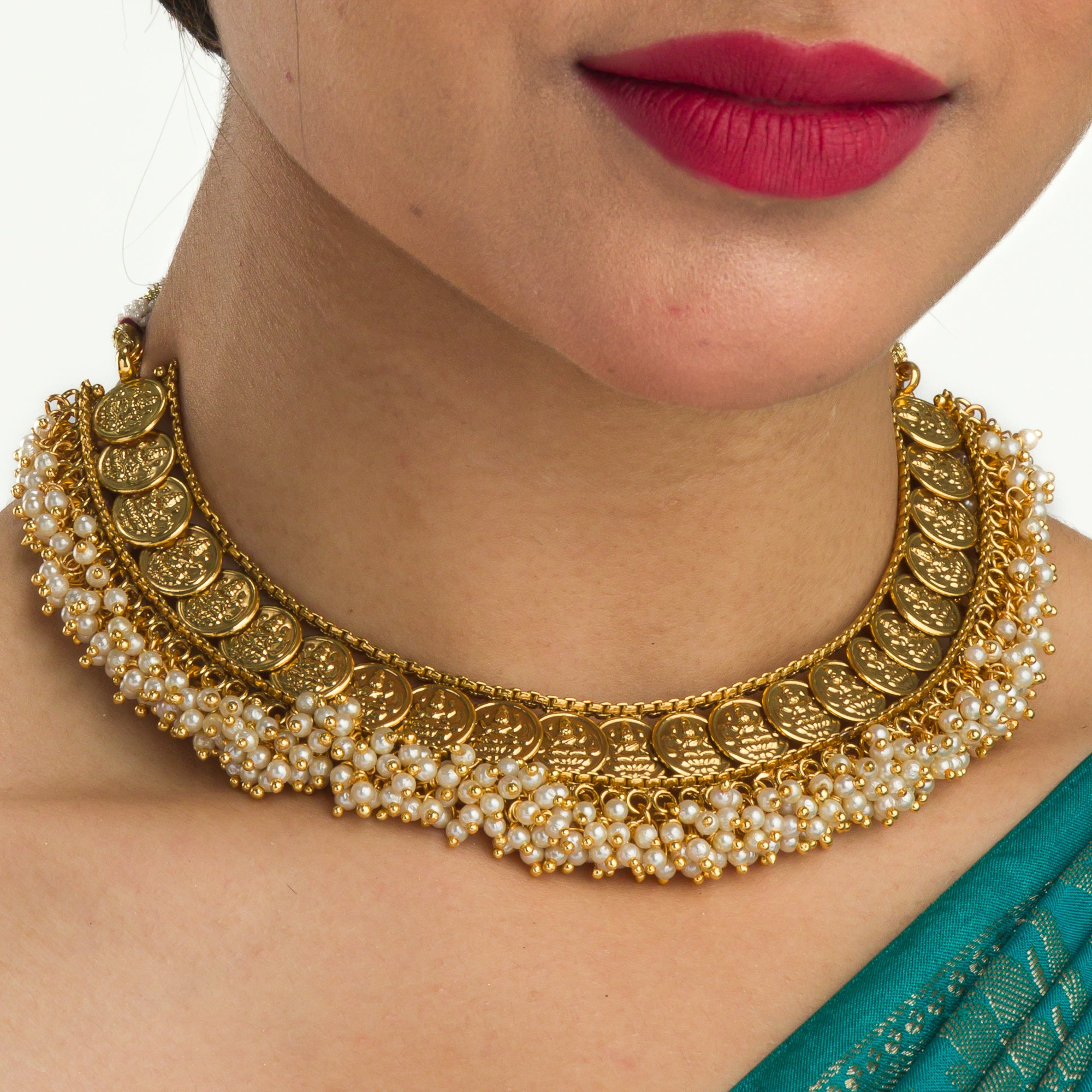 Gold-tone necklace with coin design and pearls exudes timeless elegance.
