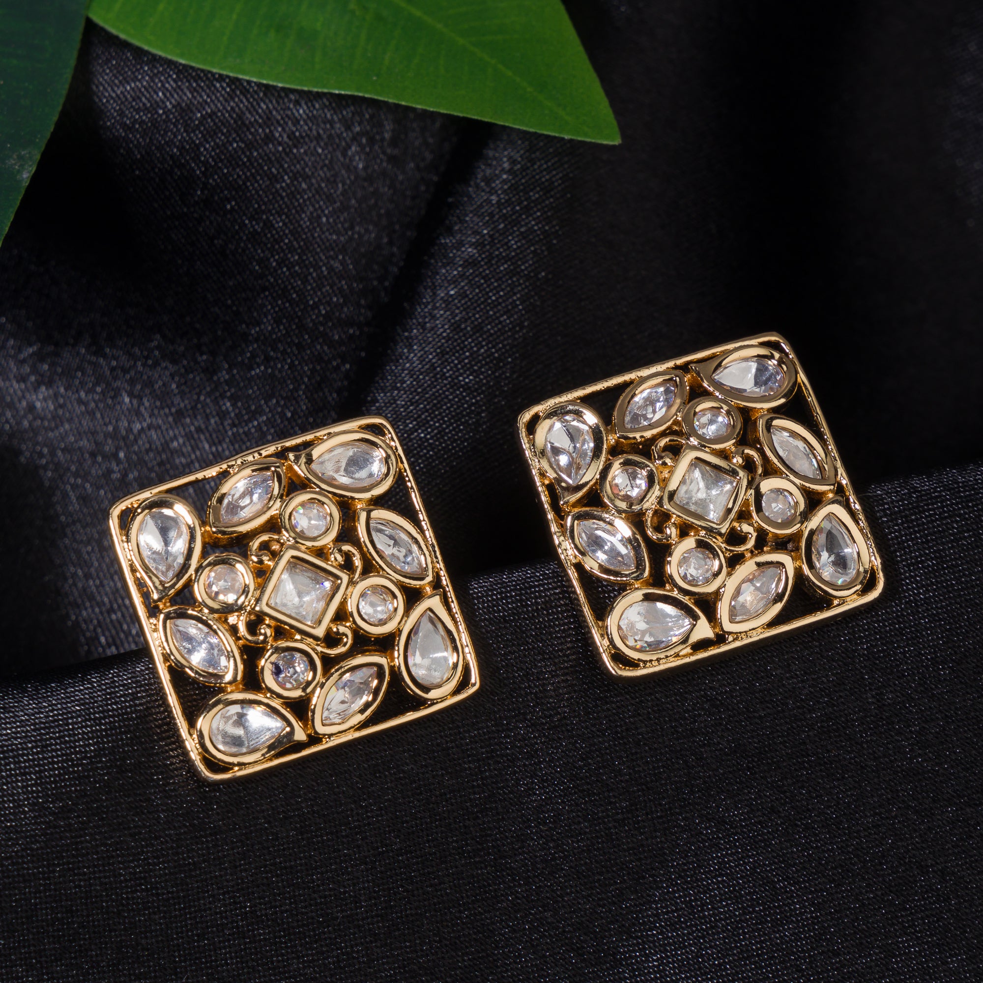Gold-tone square stud earrings offer a sleek, modern look with a sophisticated shine.
