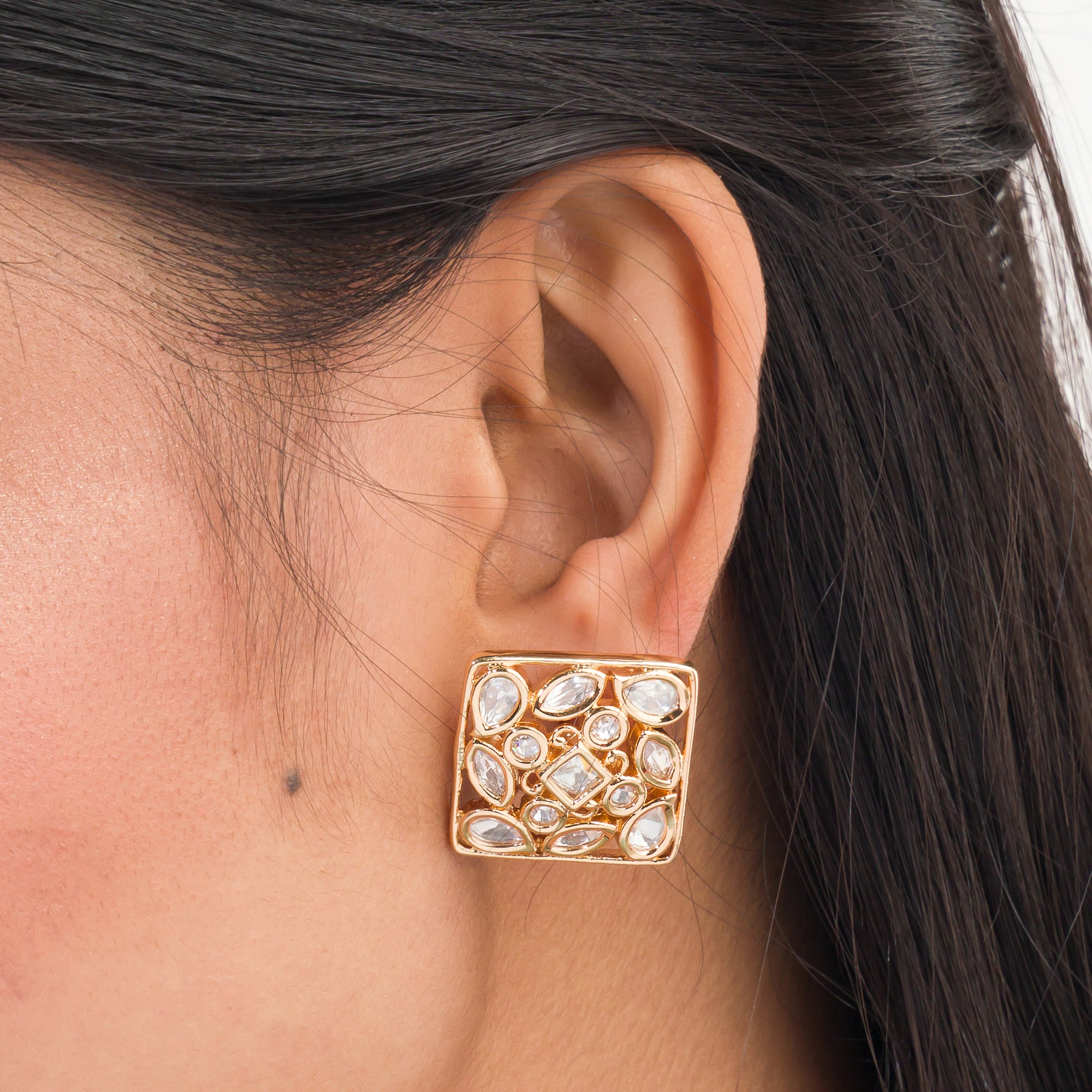 Gold-tone square stud earrings offer a sleek, modern look with a sophisticated shine.
