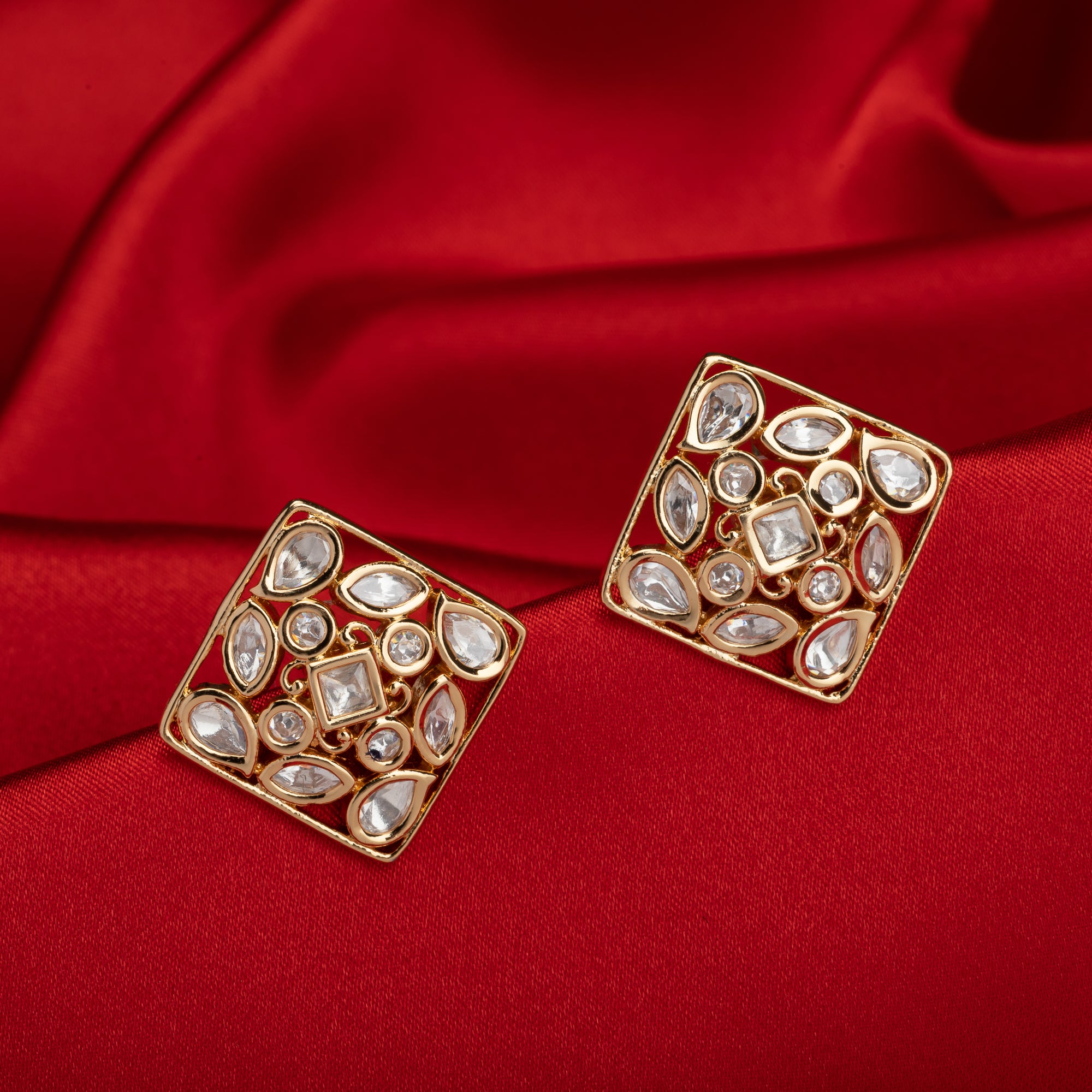 Gold-tone square stud earrings offer a sleek, modern look with a sophisticated shine.
