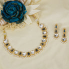 Black polished necklace set with golden, white zircon stones, and pearls for a striking elegant look.
