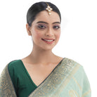 Kundan-studded goldtone maang tika with intricate detailing for a festive touch.
