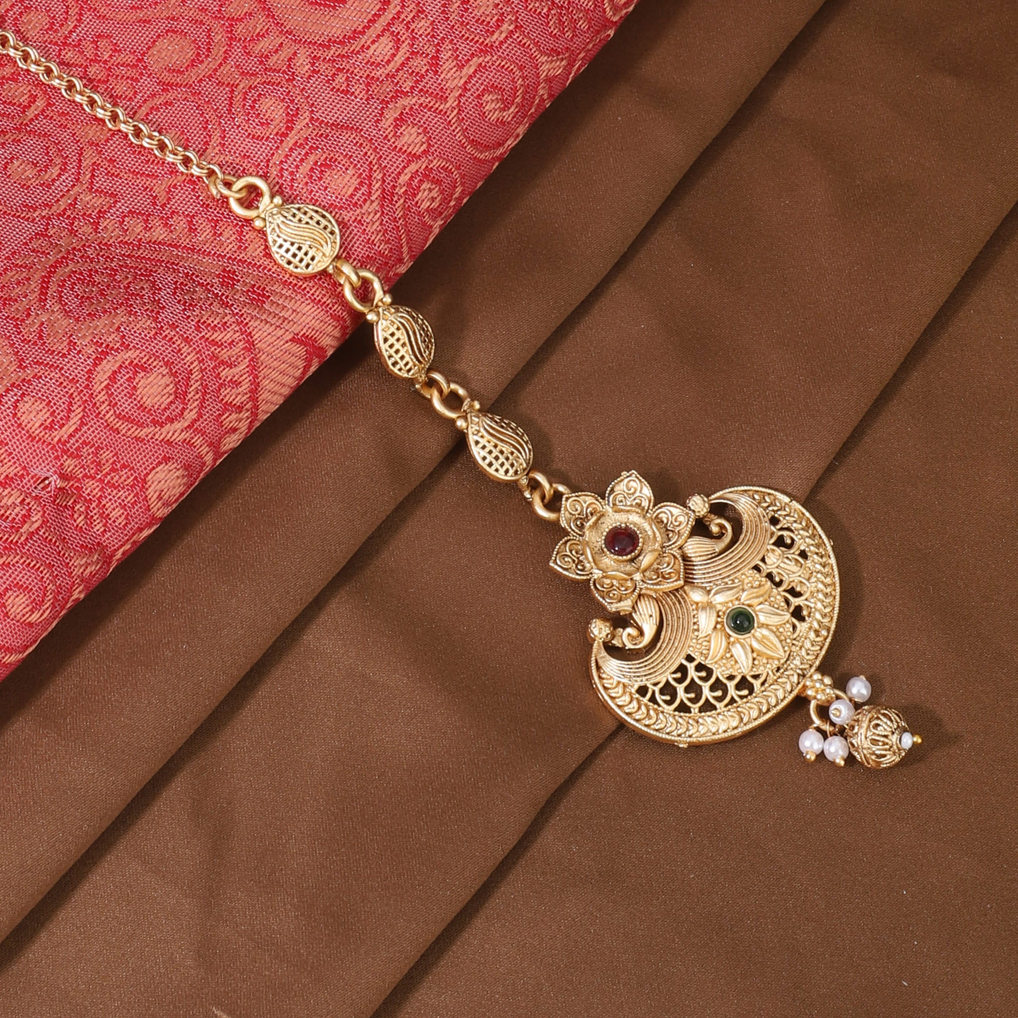 Traditional gold-tone maang tika with a golden finish, ideal for festive and elegant hairstyles.

