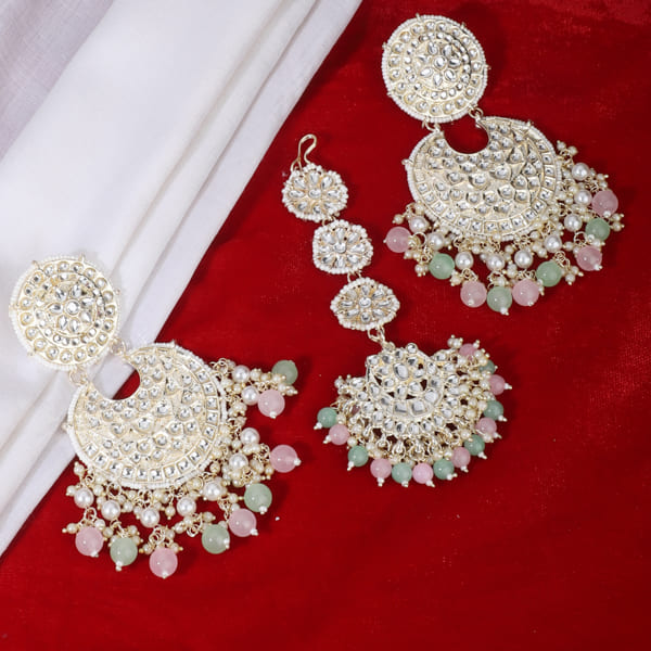 "Multicolor Kundan and pearl earrings with Maang Tikka, perfect for a classic festive style."
