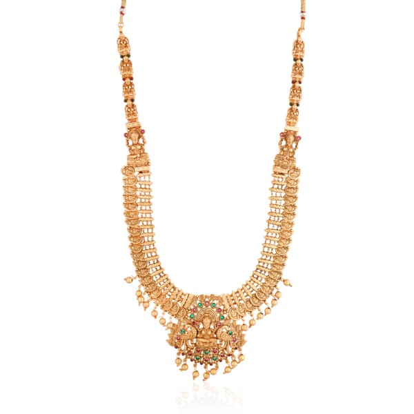 "Goldtone Laxmi Maa crafted long necklace set with matching earrings and Maang Tikka for festive elegance."
