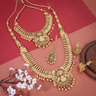 "Goldtone Laxmi Maa crafted long necklace set with matching earrings and Maang Tikka for festive elegance."
