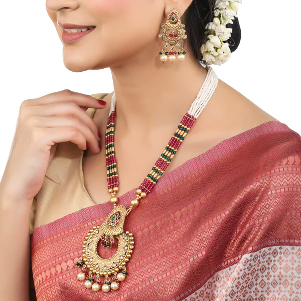 "Classic goldtone long necklace set with matching earrings for a festive, elegant look."
