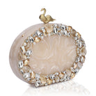 Oval-shaped salmon resin clutch with peacock design closure and sleek sling chain for style.
