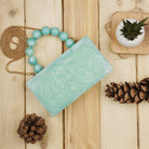 Green resin clutch with velvet lining, heavy-duty sling, and extra pocket for stylish storage.
